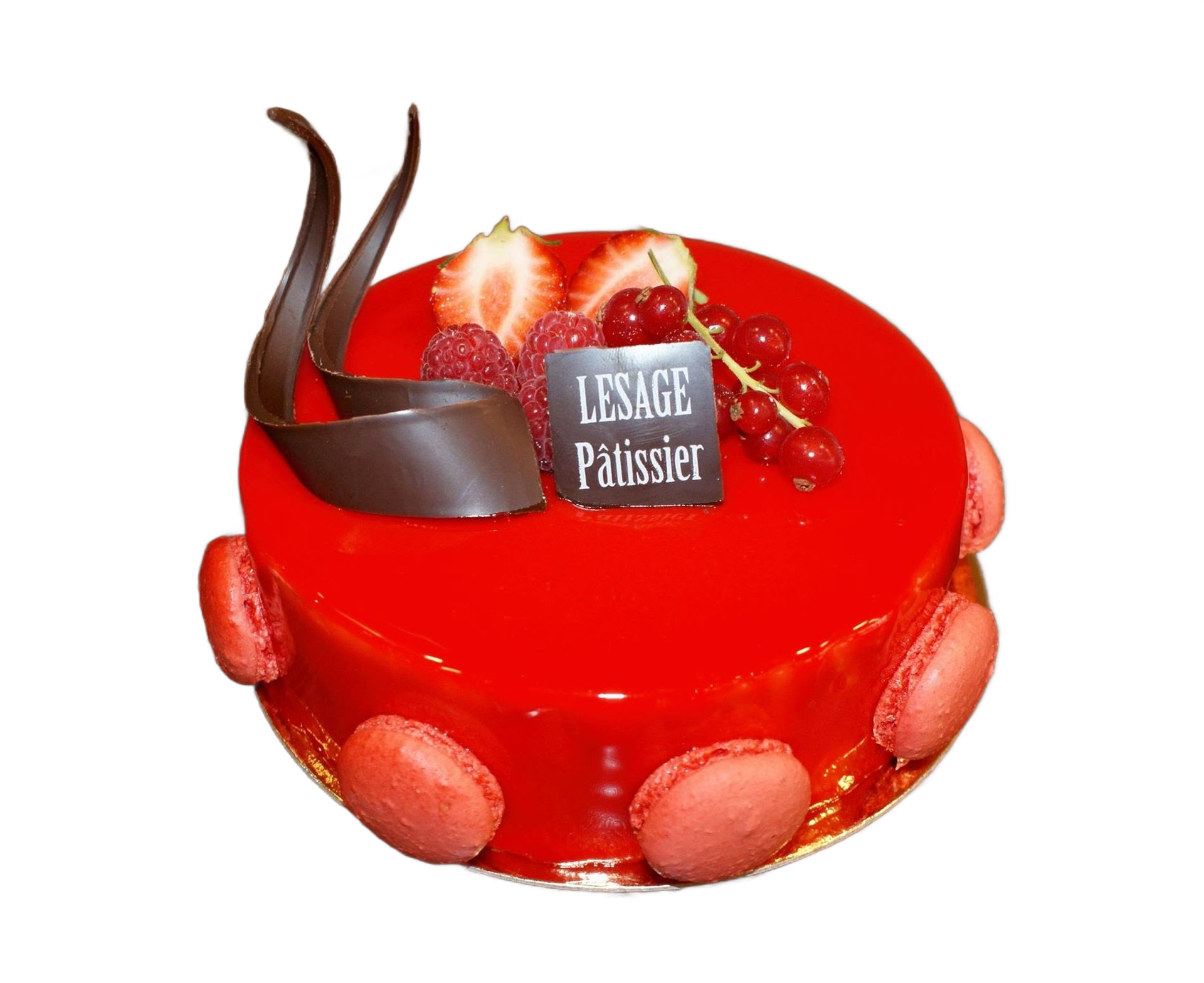Gâteau couvert d'un glaçage et garni de fraises, de copeaux de chocolats et macarons.