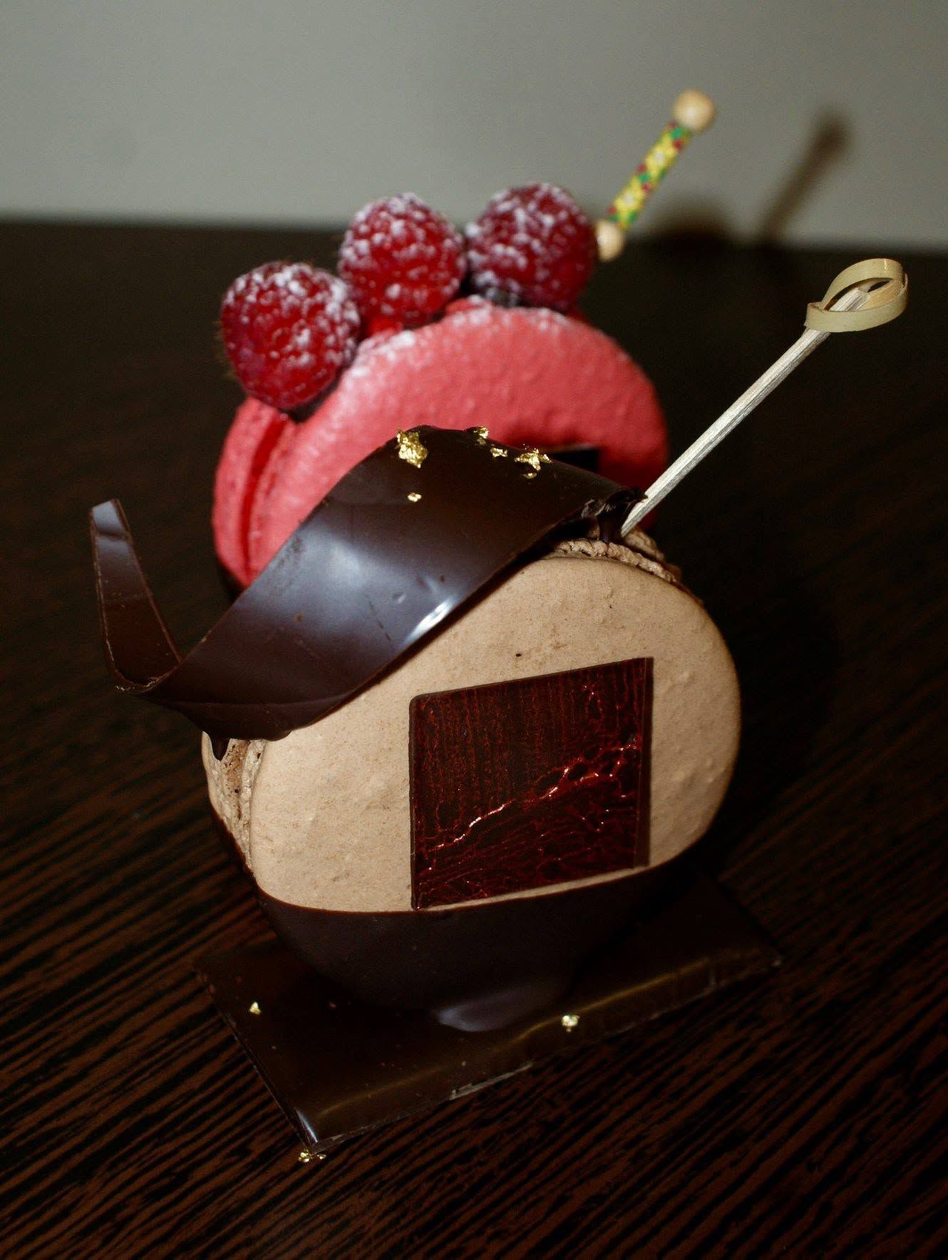 Un macaron au café et un macaron à la framboise décorés.