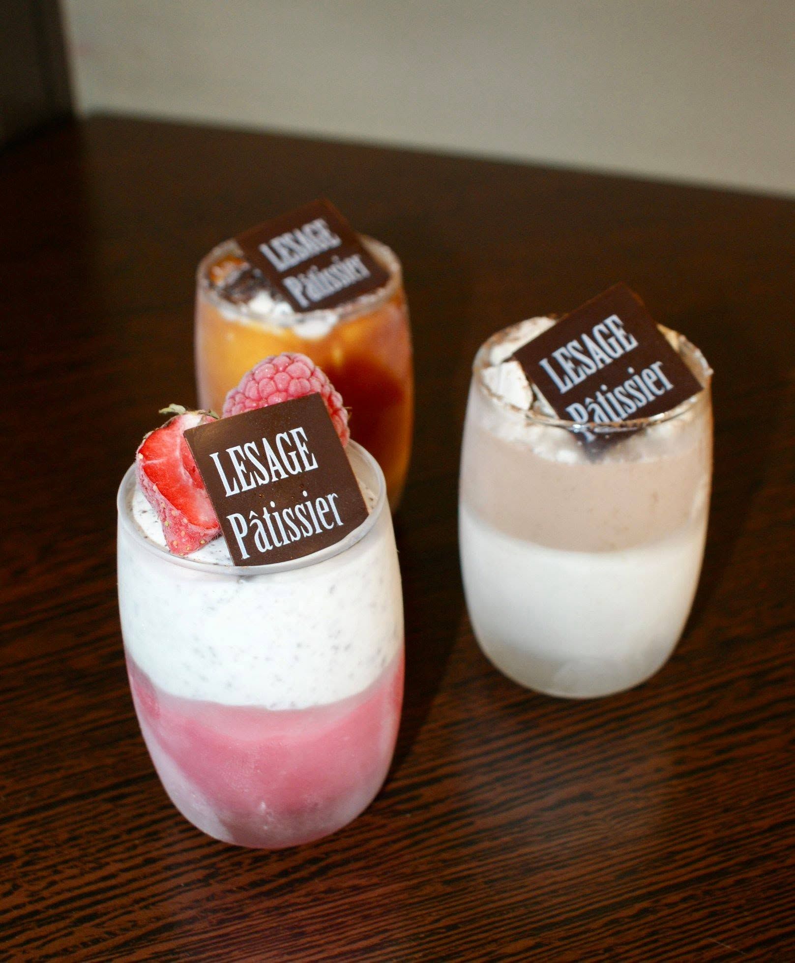 Trois verrines glacées garnies de fruits rouges et de chocolat.