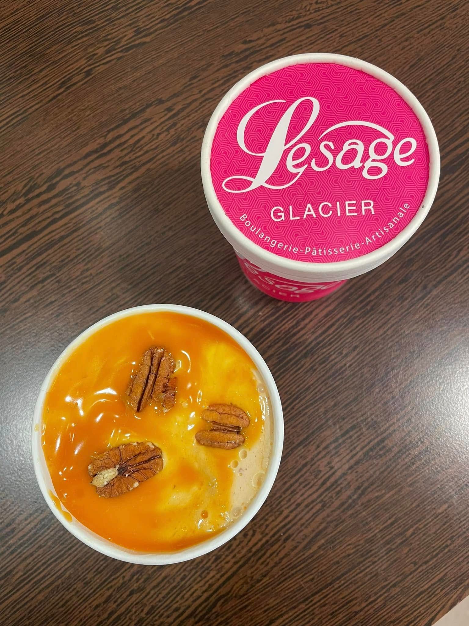Un pot de glace fermé et un pot de glace ouvert avec un coulis de caramel et des noix de pécan.