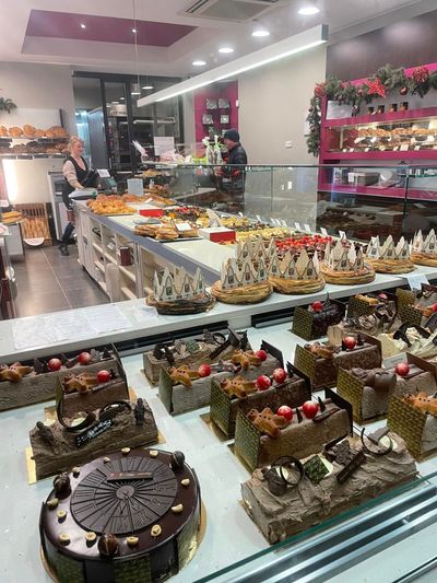 Vitrine de boulangerie présentant un assortiment de gâteaux, pâtisseries et desserts décorés dans une boutique lumineuse