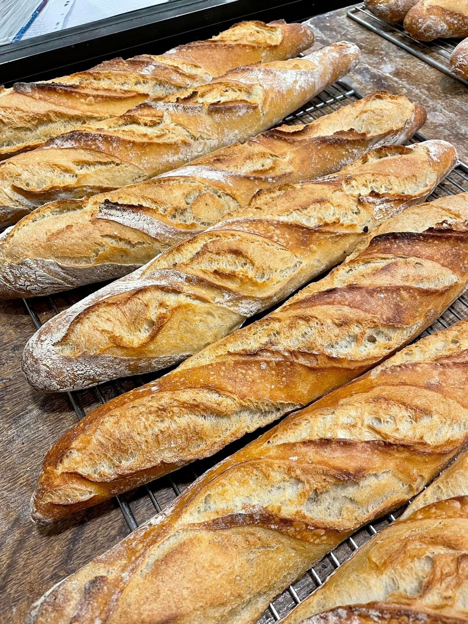 Plateau de baguettes dorées refroidissant sur une grille.