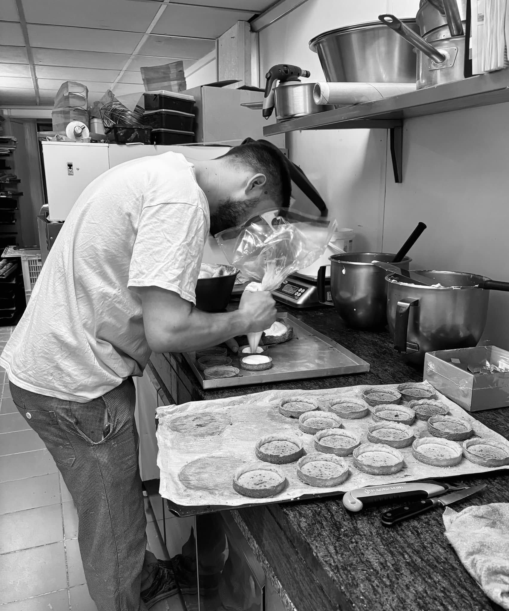 Une personne prépare des pâtisseries dans une cuisine.