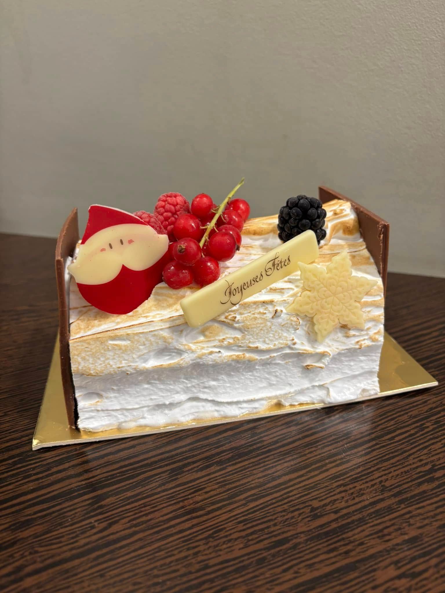 Bûche couverte de meringue et de fruits rouges.