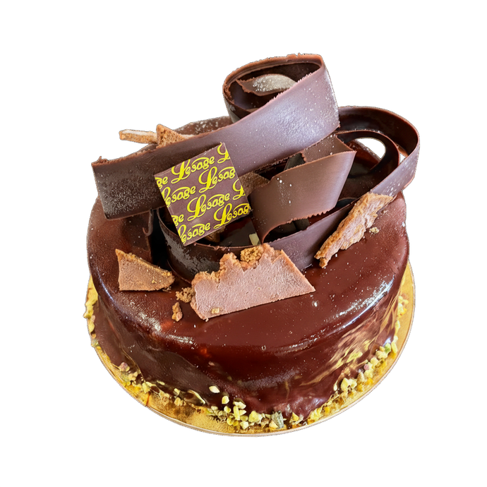Gâteau au chocolat décoré de copeaux de chocolat et d'éclats de pistache.