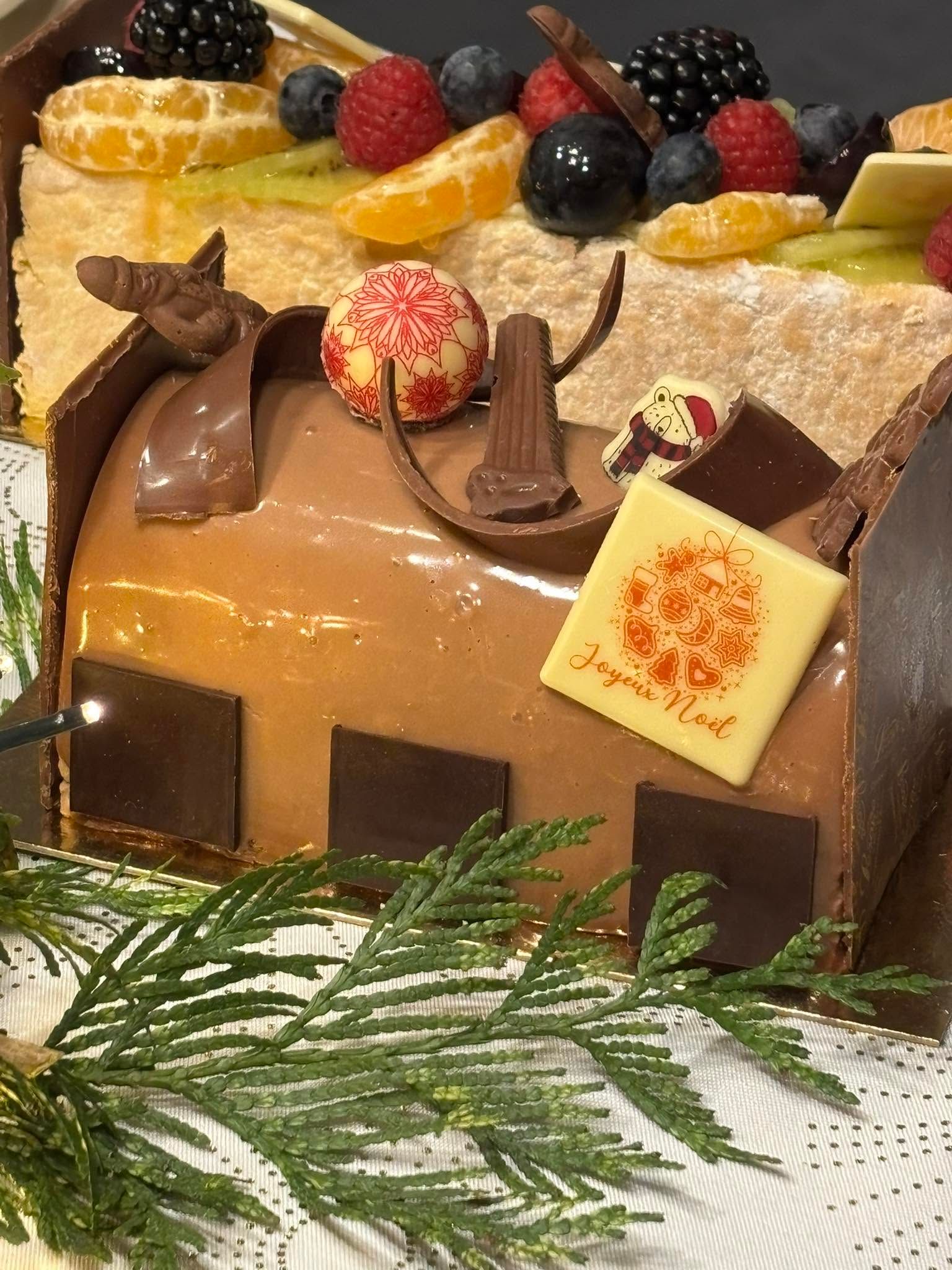 Deux bûches de Noël décorées de fruits et de chocolat.