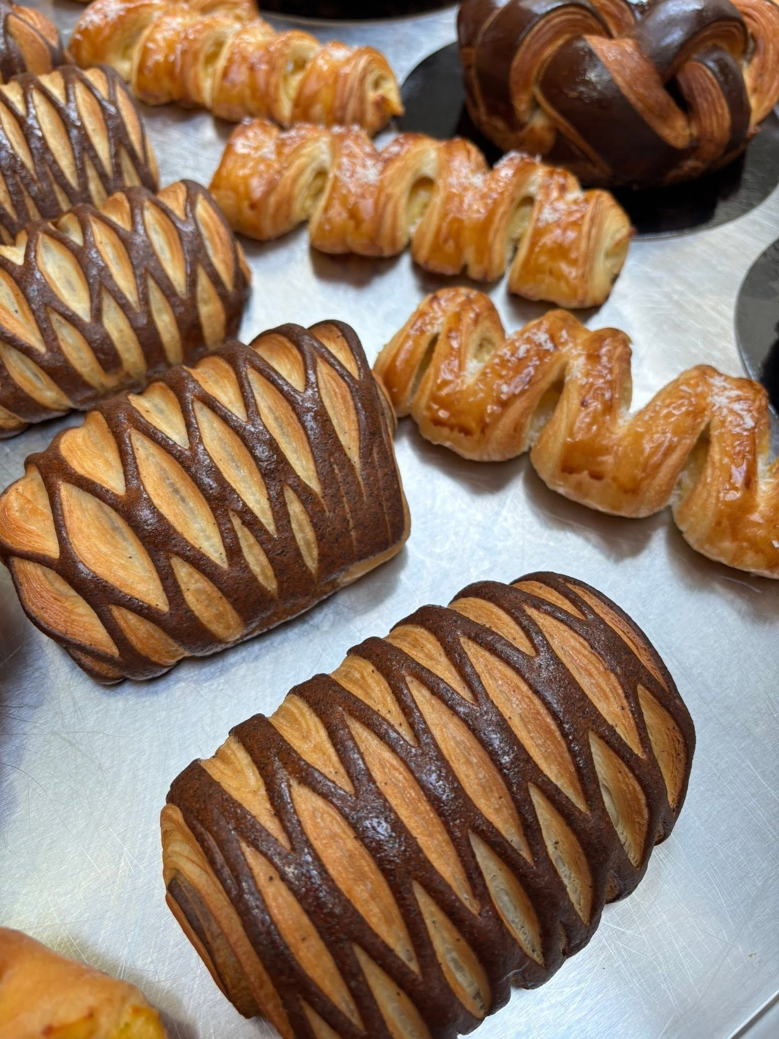 Assortiment de viennoiseries disposées sur un plateau.