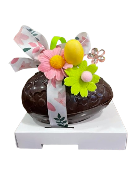 Œuf en chocolat décoré d'un noeud et de fleurs.
