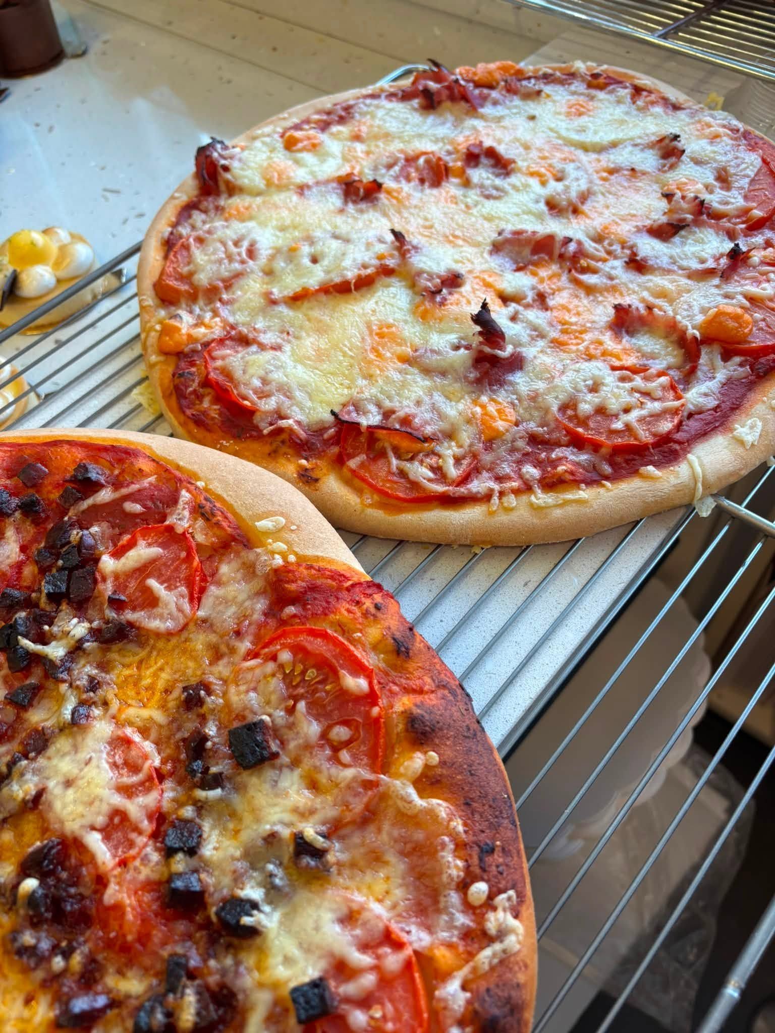 Deux pizzas maison refroidissent sur une grille.