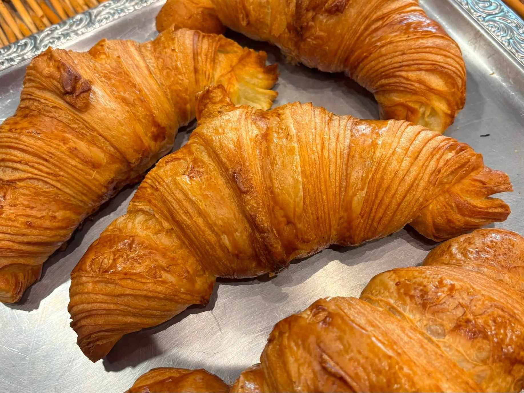Des croissants dorés sur un plateau en argent.