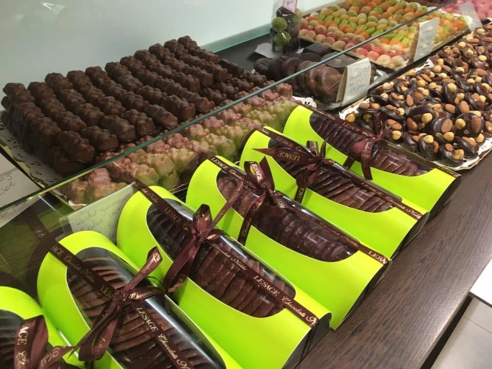Des tuiles en chocolat dans une vitrine et dans des boîtes à offrir