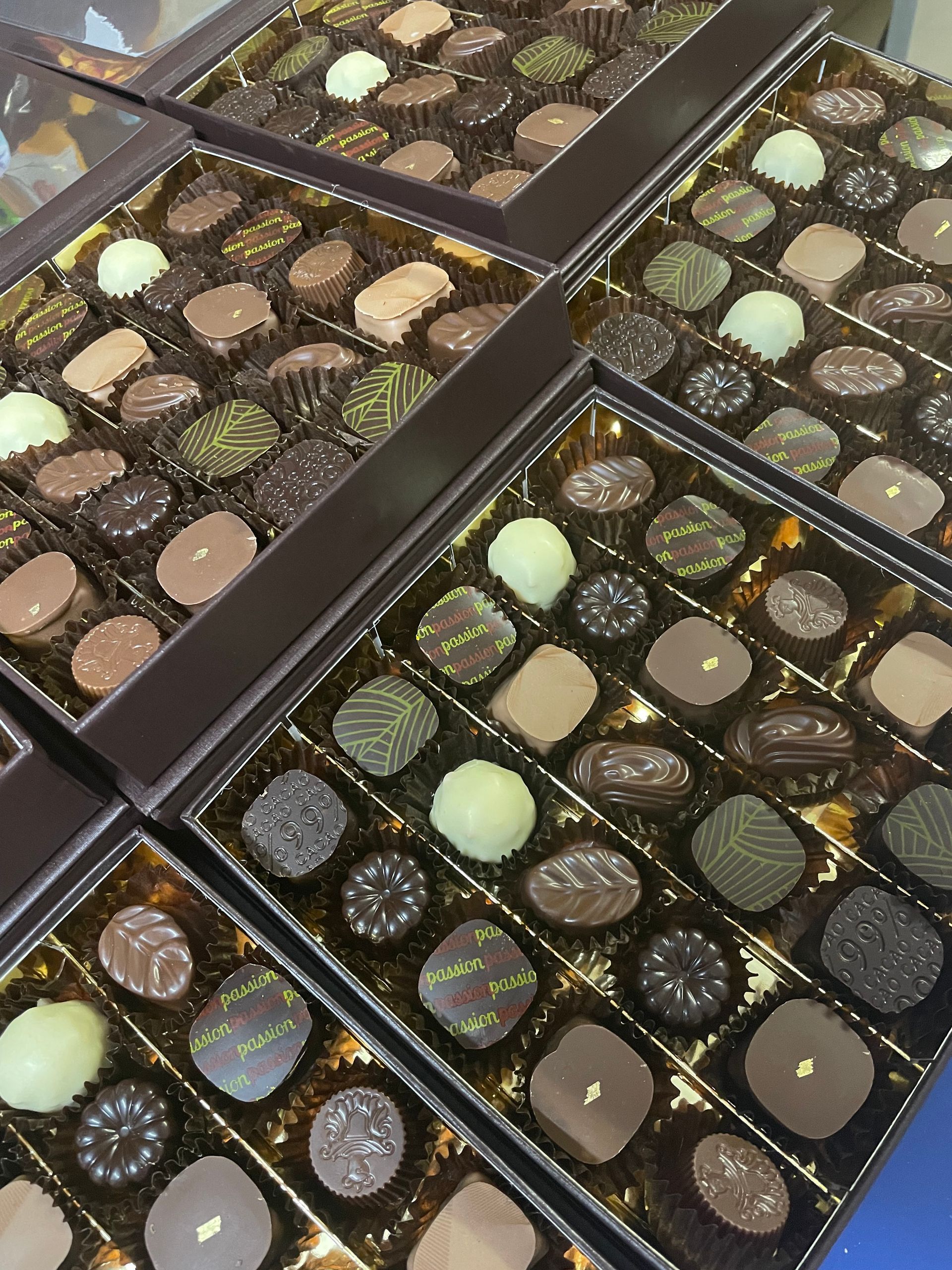 Des tuiles en chocolat dans une vitrine et dans des boîtes à offrir
