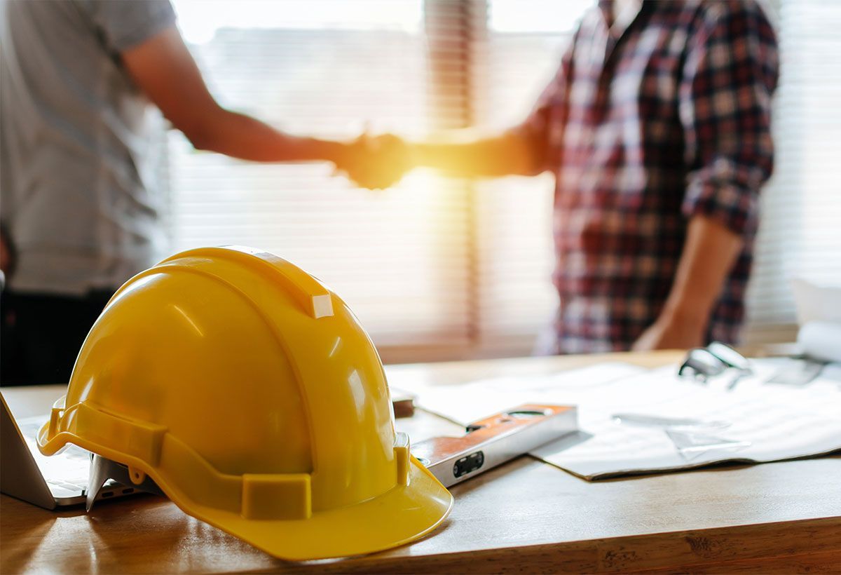 Poignée de main entre deux hommes debout dans un bureau de chantier
