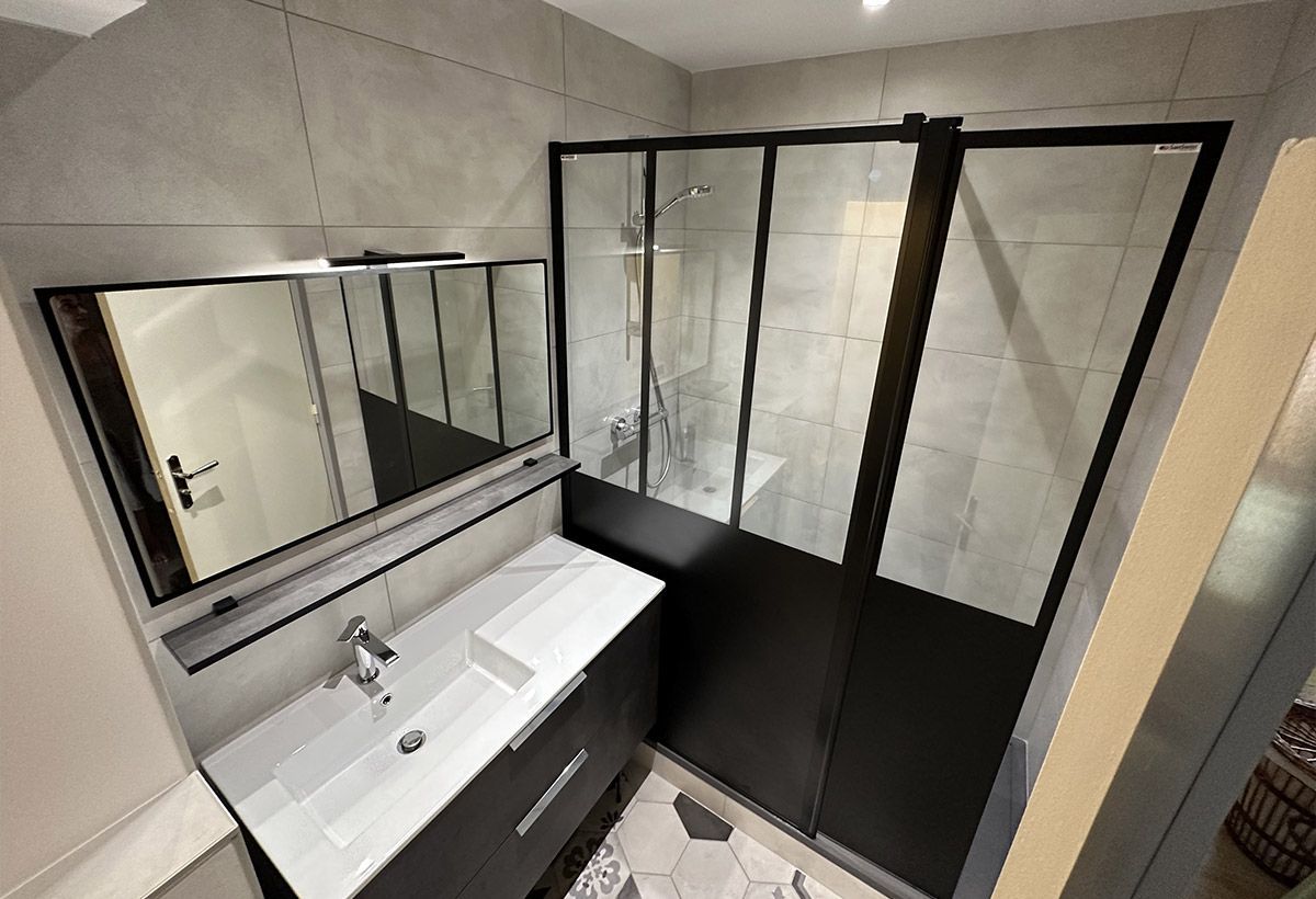 Salle de bains comportant une douche avec une paroi métallique