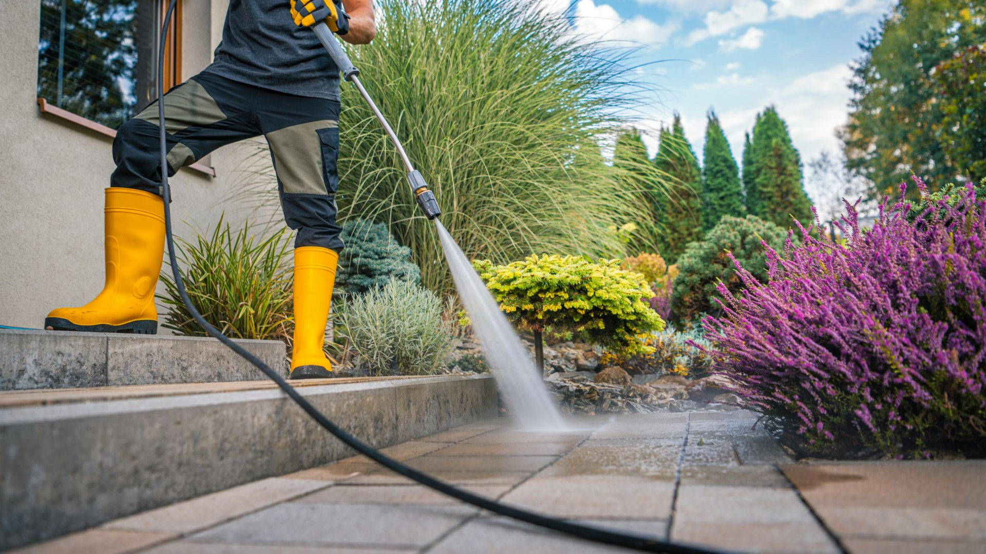 Une personne nettoie une terrasse en pierre.
