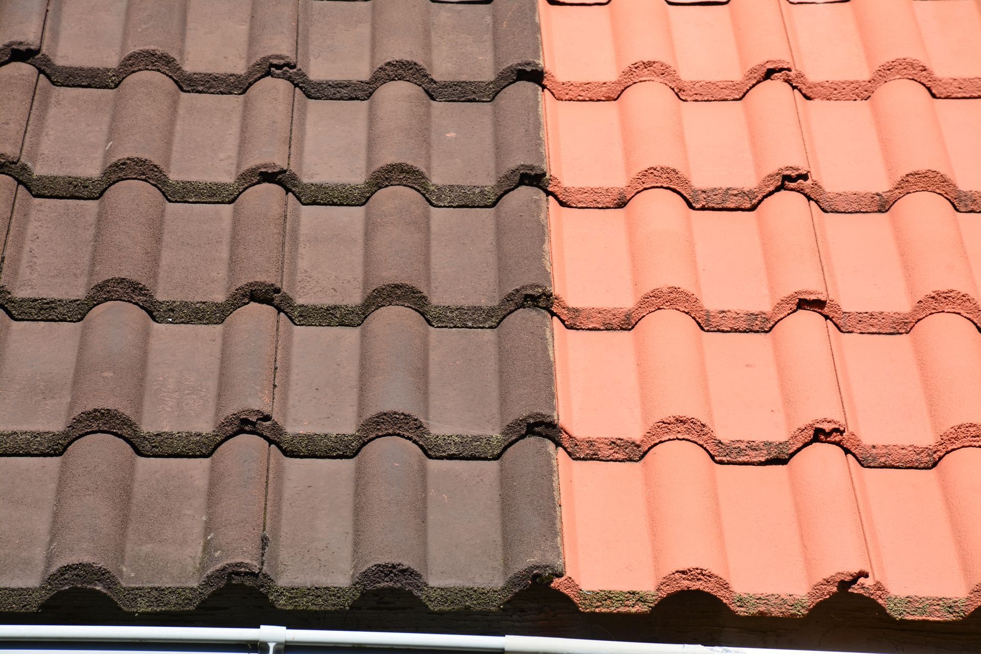 Une personne nettoie une terrasse en pierre au nettoyeur haute pression.