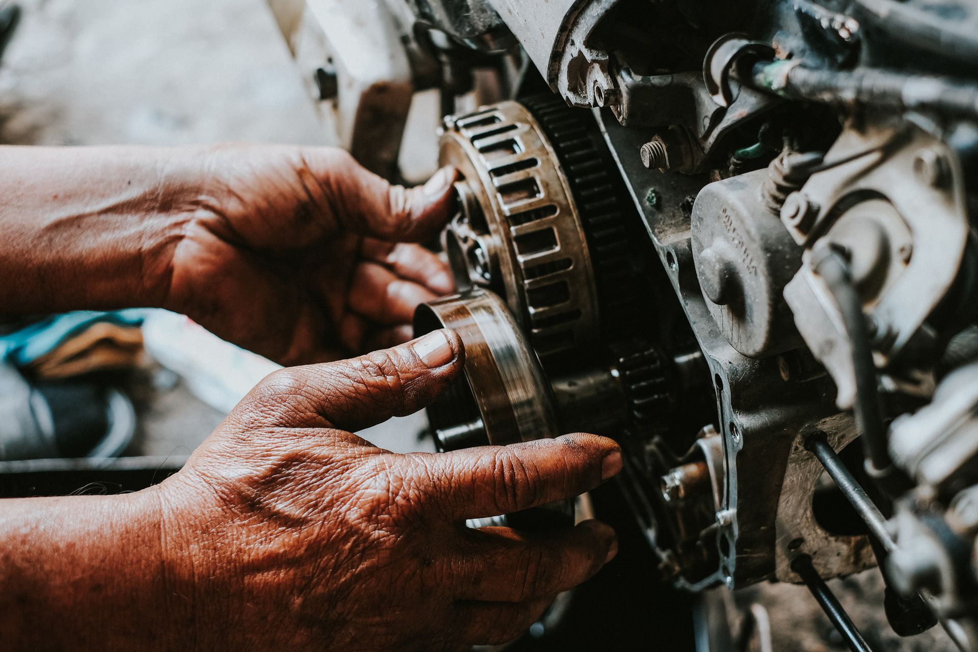 Mains travaillant sur un moteur de moto, assemblage d'un ensemble d'engrenages, gros plan, huileux, intérieur.