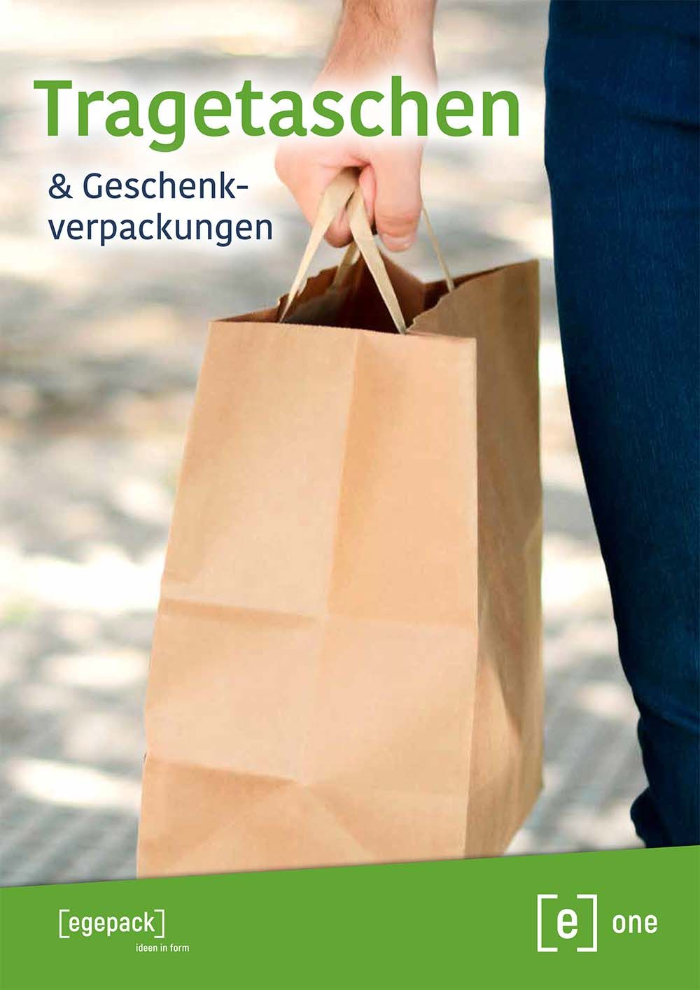 Eine Person hält eine braune Papiertüte mit der Aufschrift „tragetaschen“