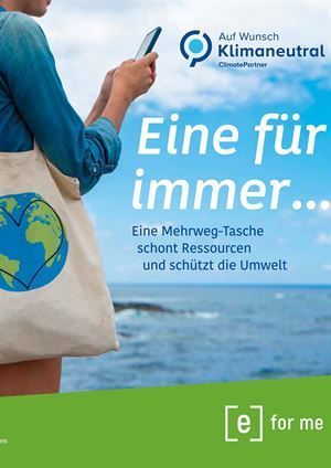 Eine Frau hält eine Einkaufstasche und sieht auf ihr Telefon.