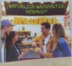 A group of people standing in front of a sign that says naturlich nachhaltig verpackt