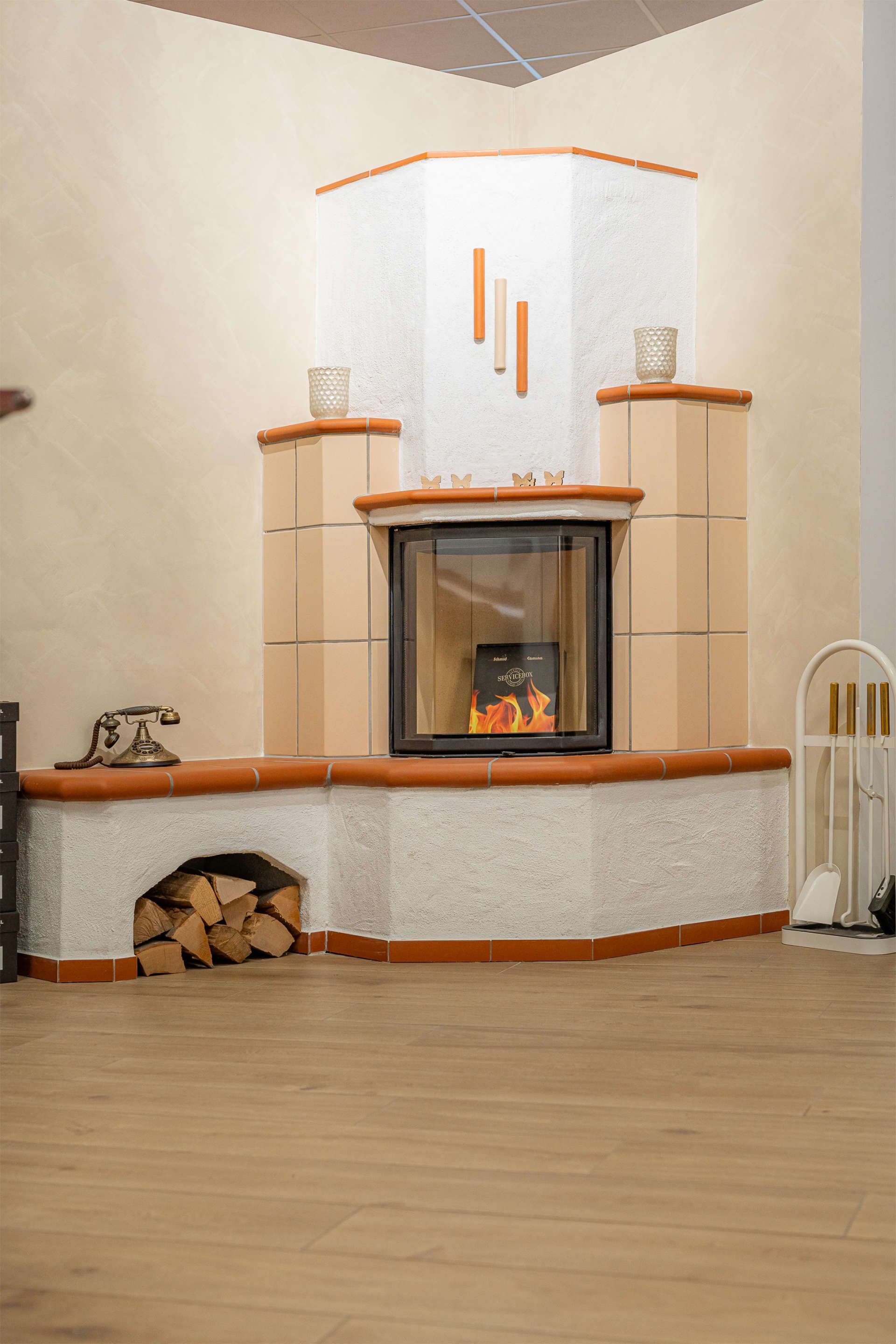 Kachelofen in der Ecke eines Raumes mit beigen und terrakottafarbenen Fliesen