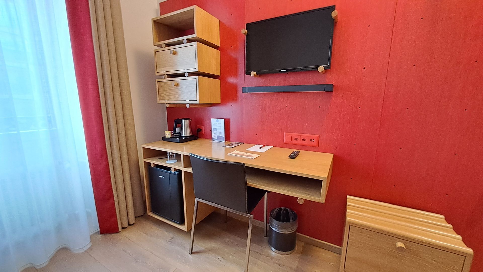 Une chambre d'hôtel avec un lit, un bureau et une télévision.