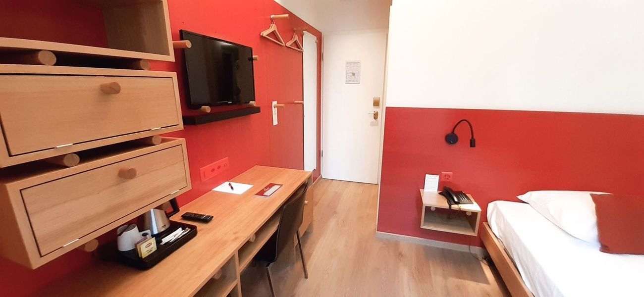 Une chambre d'hôtel avec deux tasses, une bouilloire et un bloc-notes