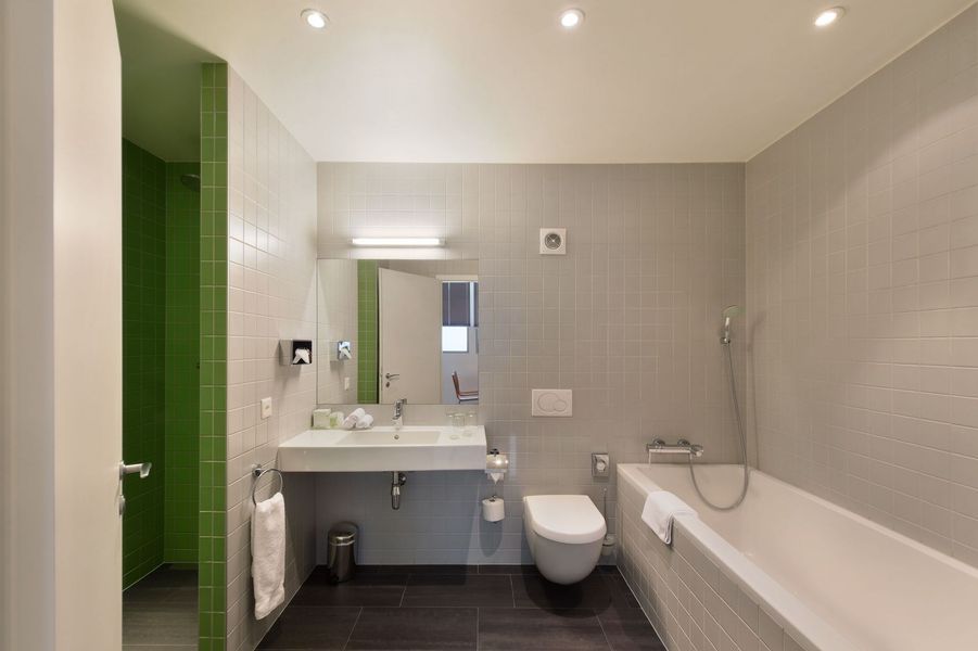 Une salle de bain avec baignoire, toilettes, lavabo et miroir