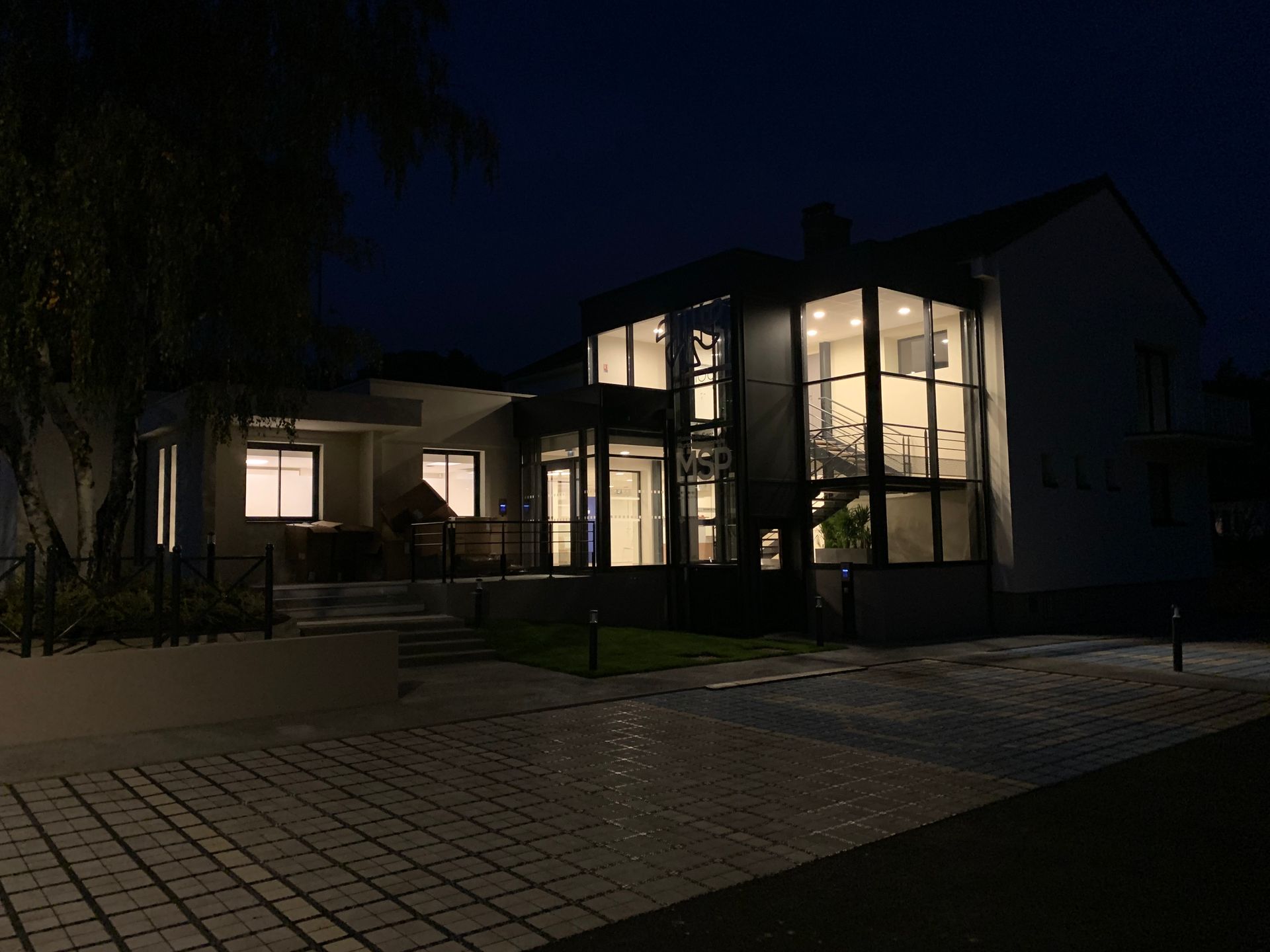 Maison vitrée éclairée dans la nuit