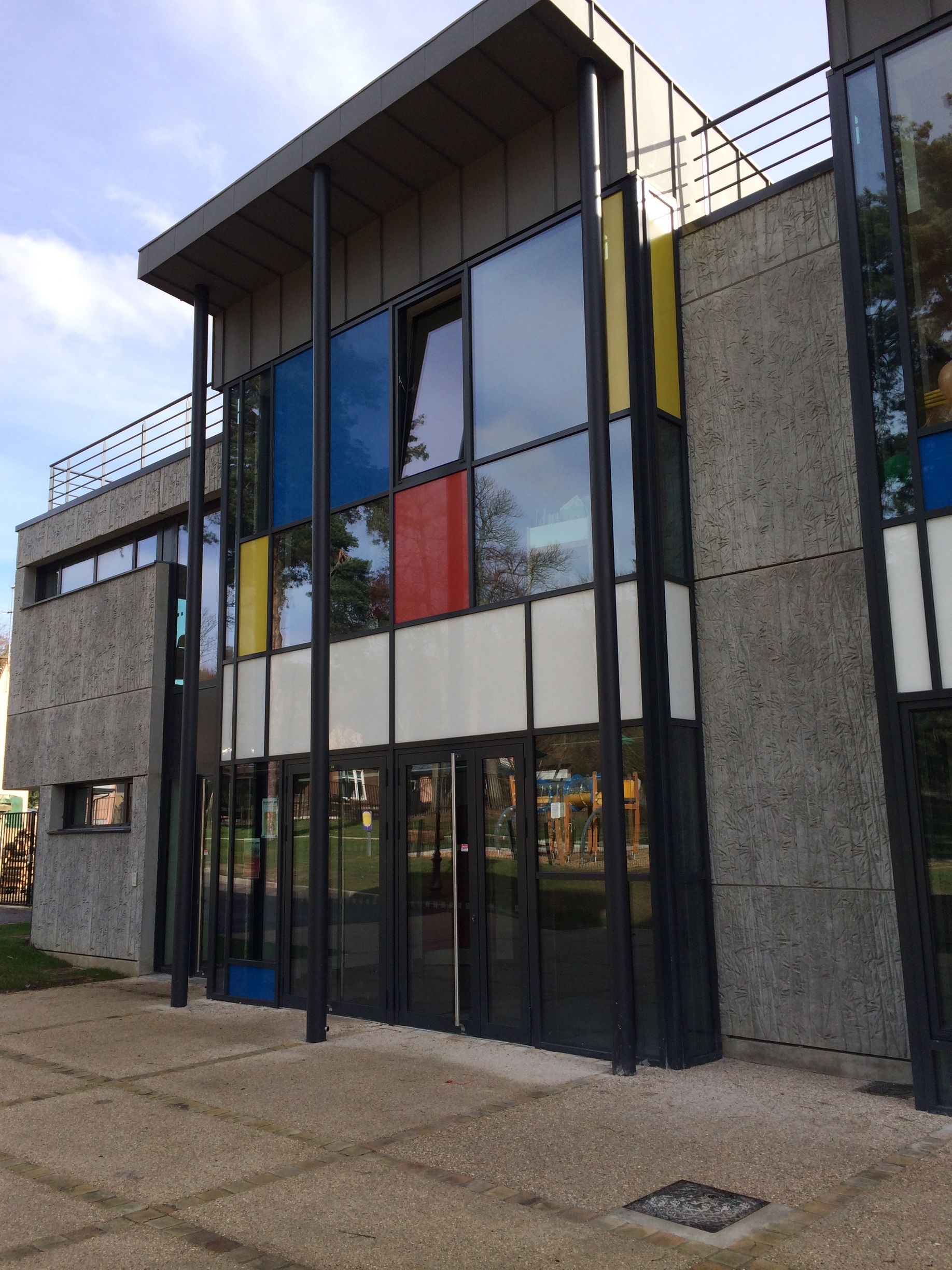 Façade d'un bâtiment professionnel avec porte d'entrée et vitres en aluminium
