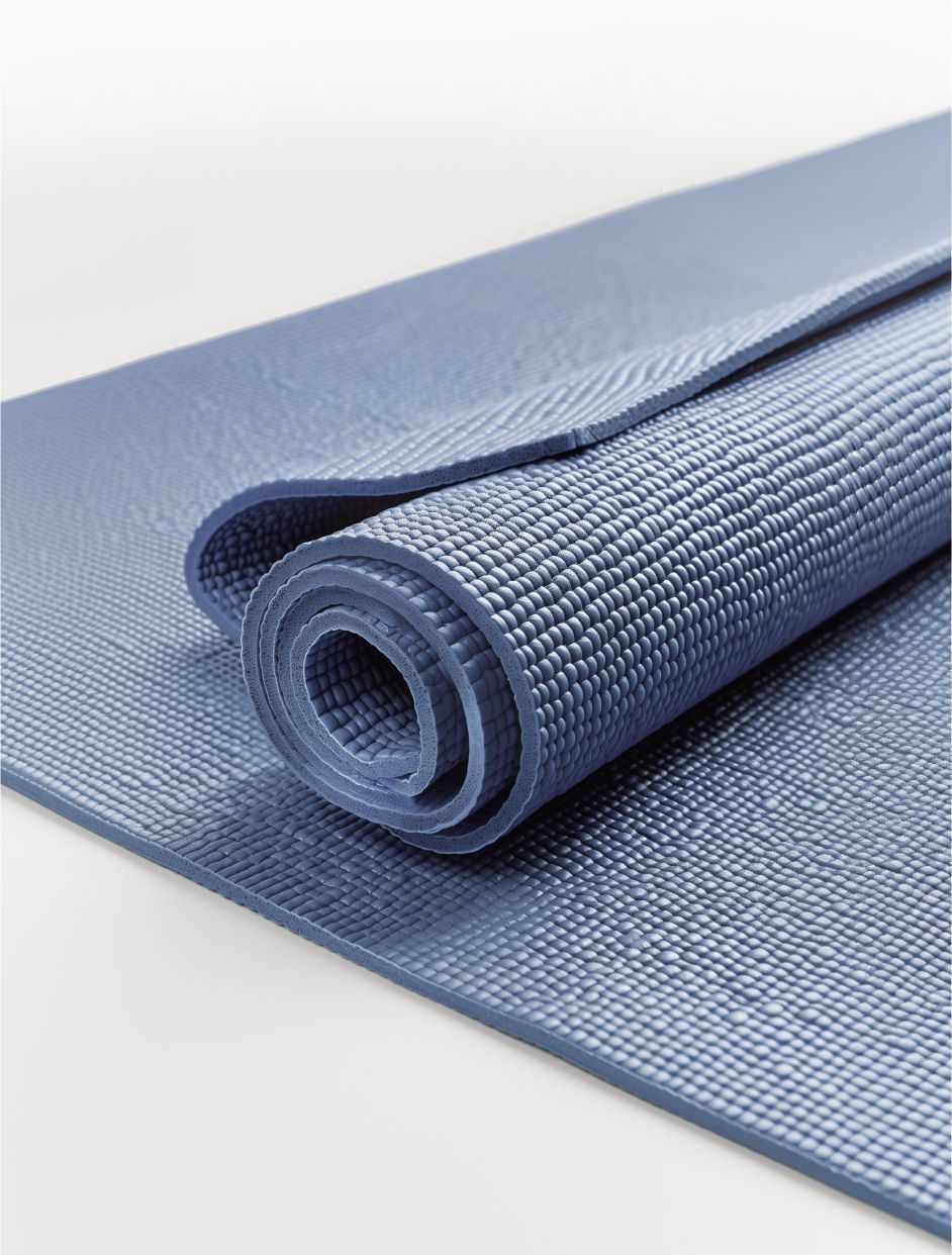 Tapis de yoga gris texturé enroulé sur fond clair