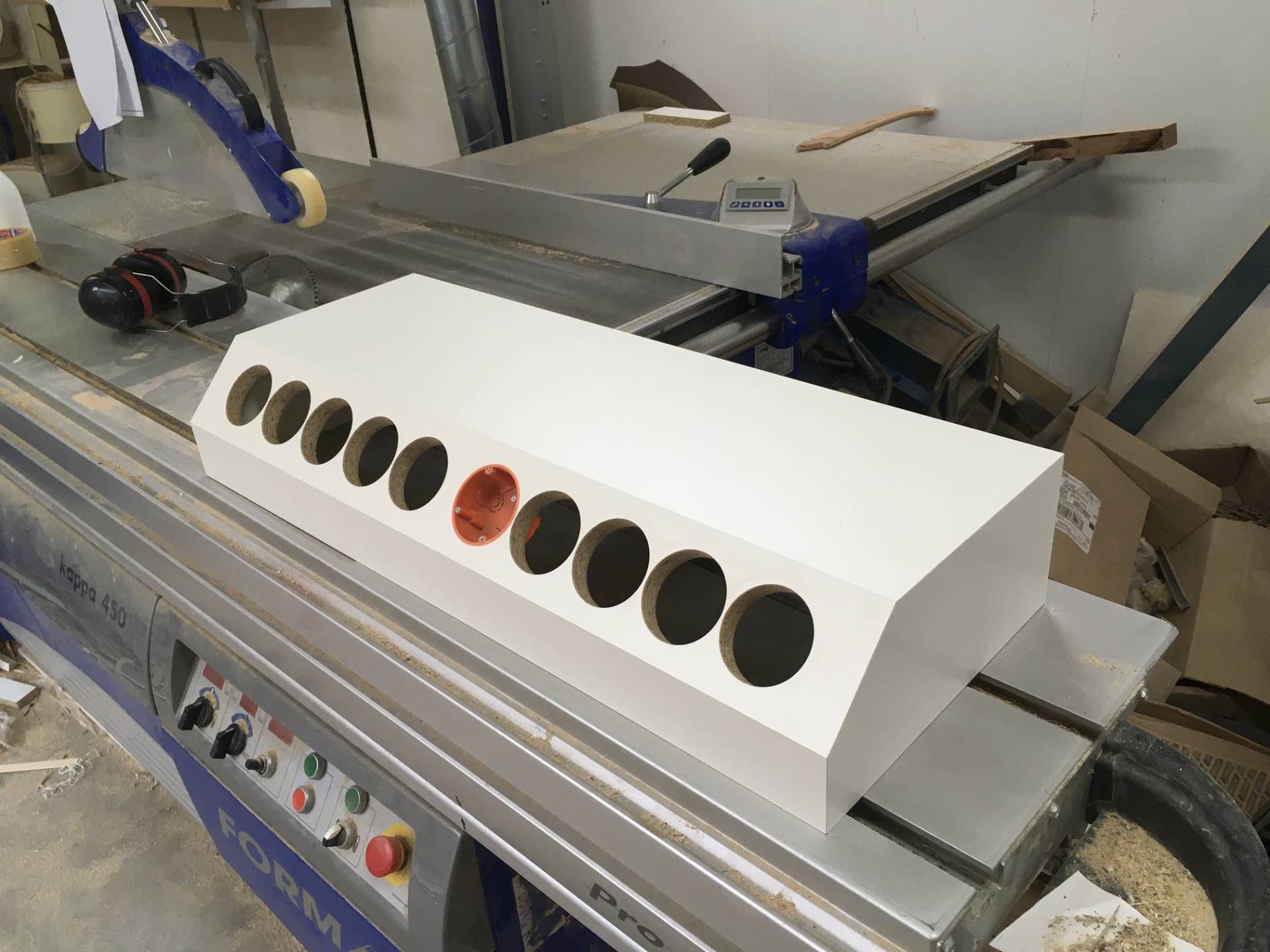 Auf einer Maschine steht ein weißer Kasten mit Löchern.