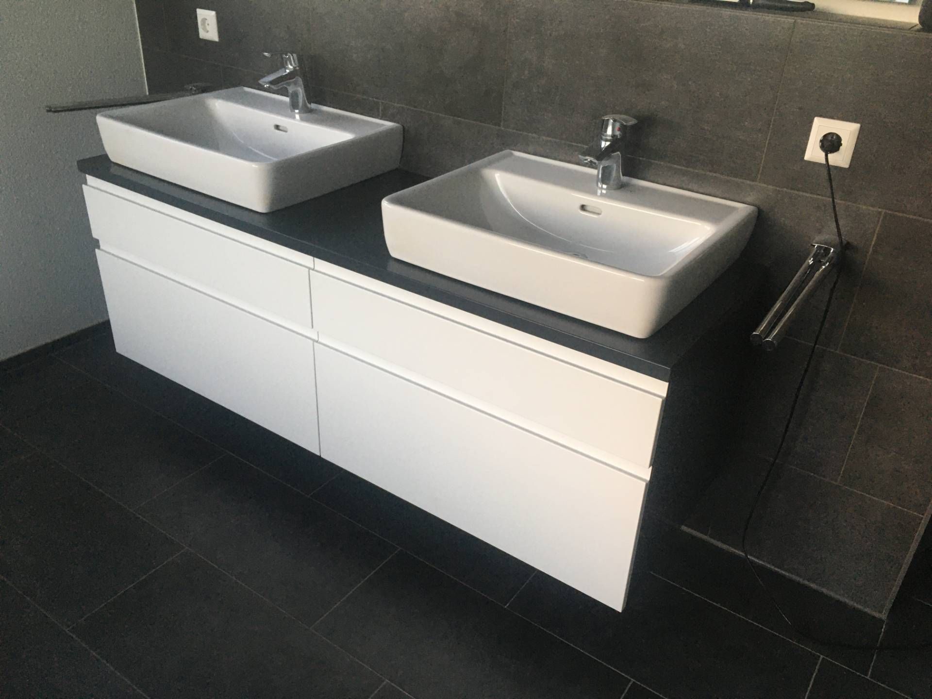 Ein Badezimmer mit zwei Waschbecken und einem Handtuchhalter.