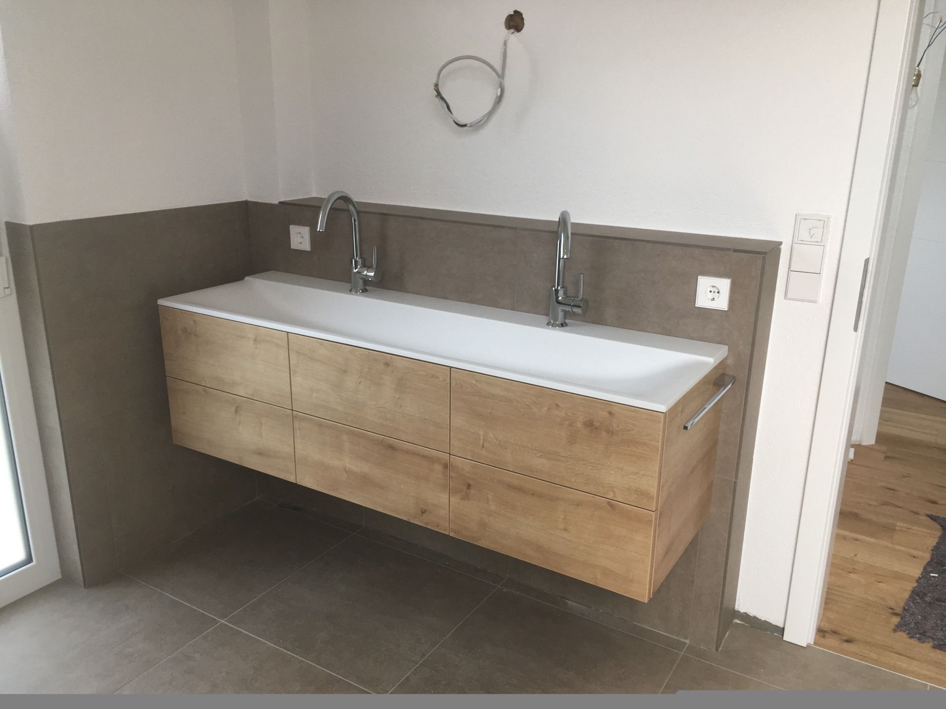 Ein Badezimmer mit einem Waschbecken und zwei Wasserhähnen.