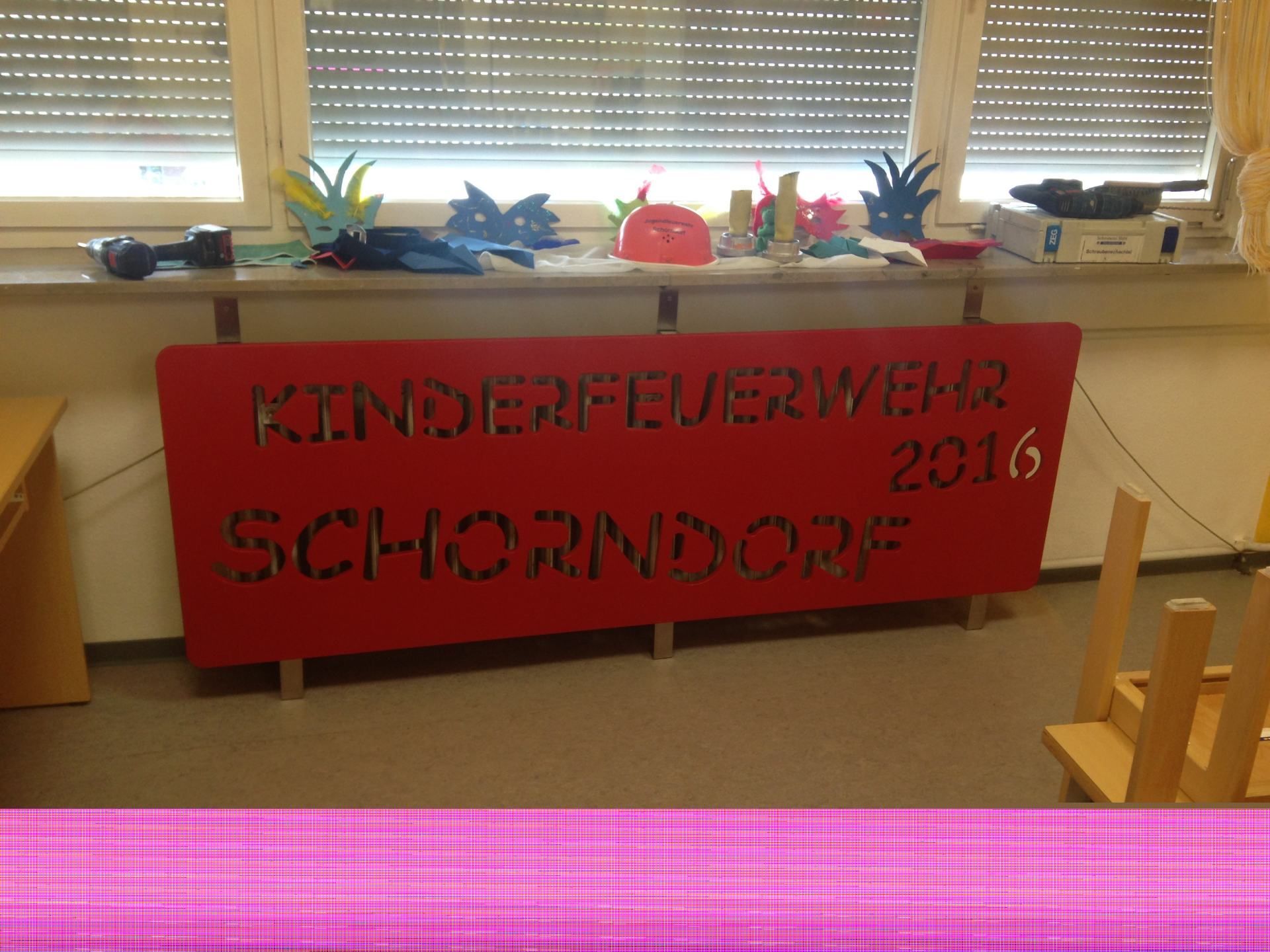 Ein rotes Schild mit der Aufschrift Kinderfeuerwehr 2016.