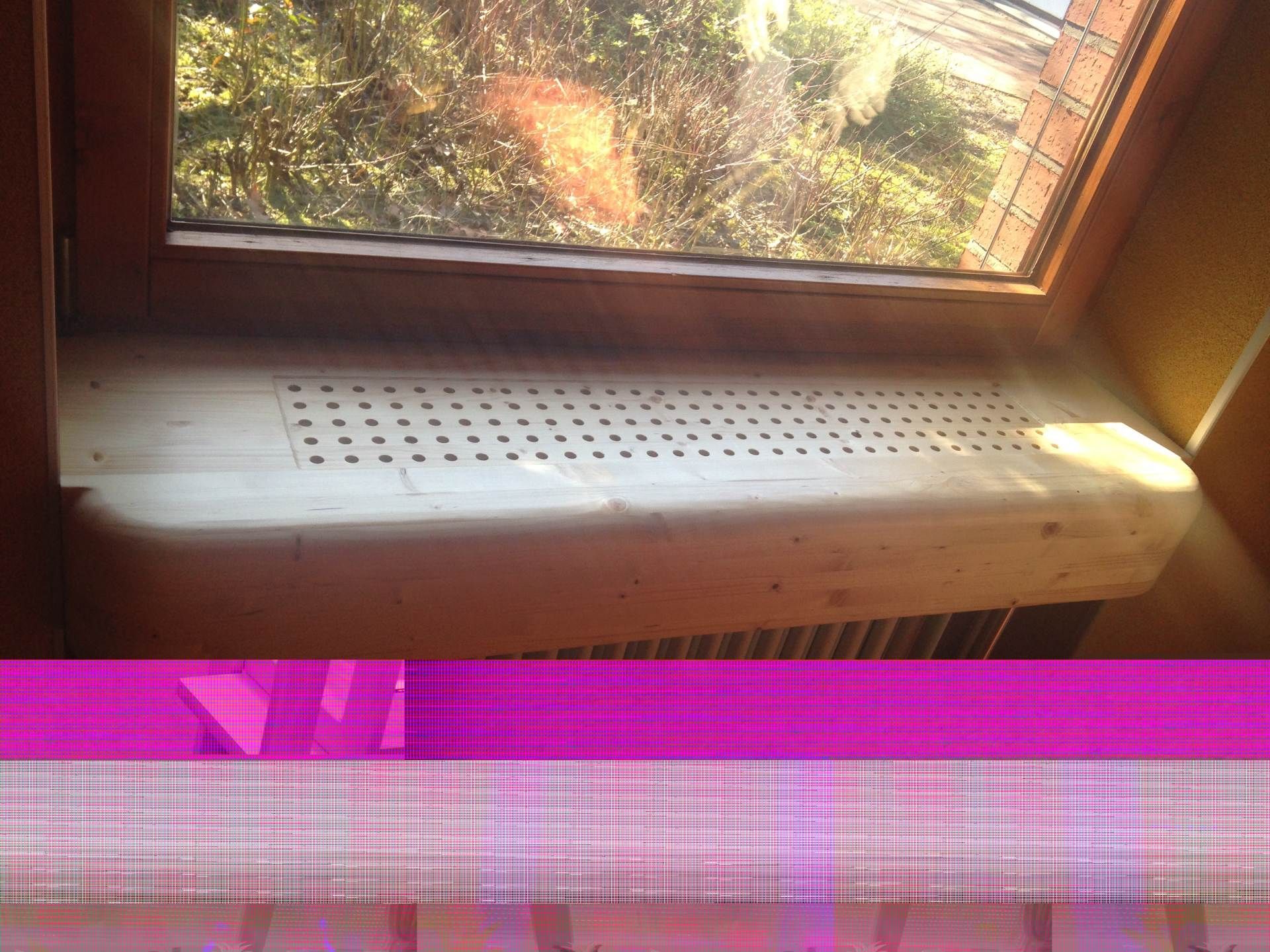 Ein Fensterbrett mit Löchern darin und einem violetten Hintergrund.