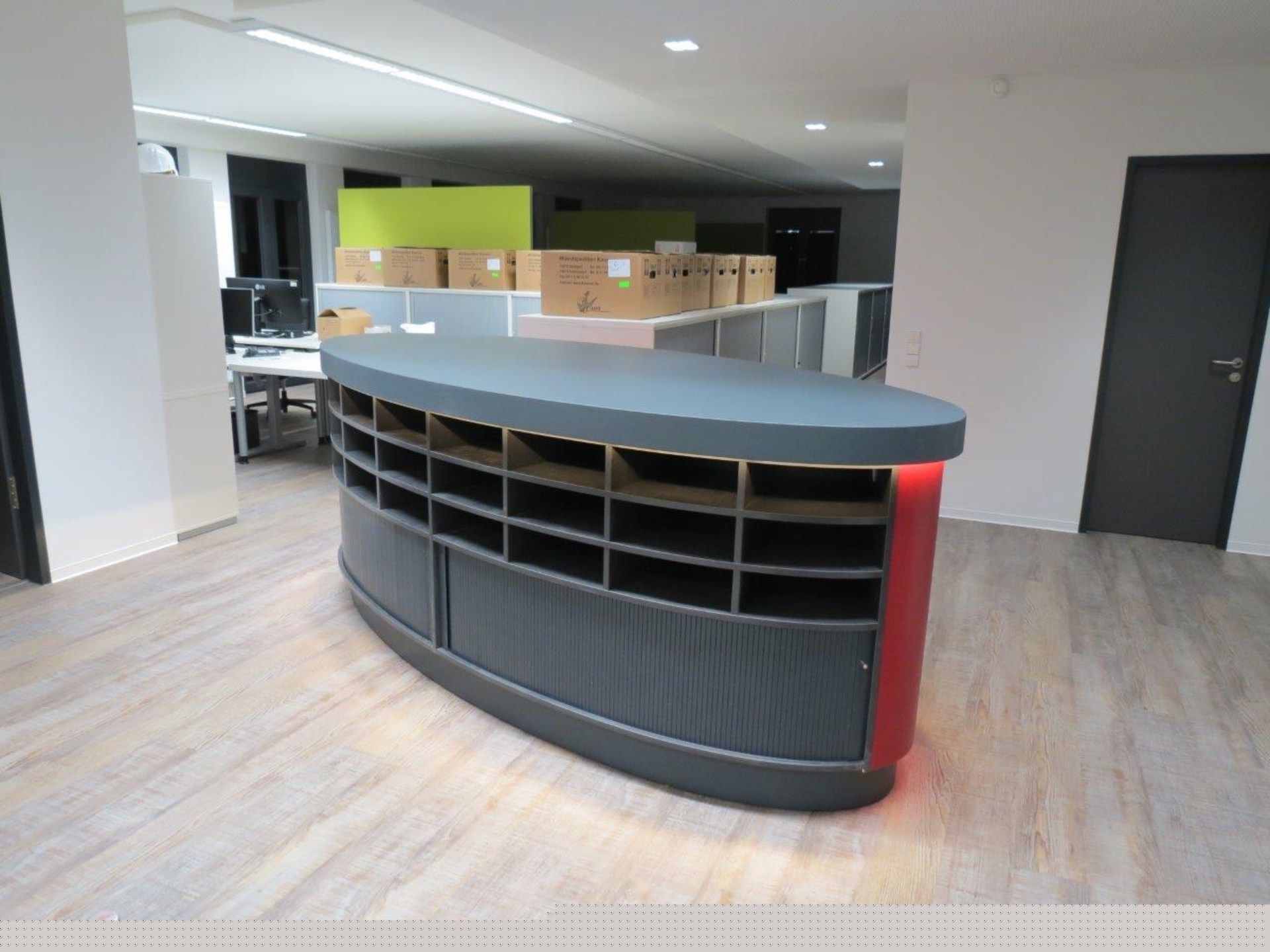 Ein großer Raum mit einer geschwungenen Theke in der Mitte.