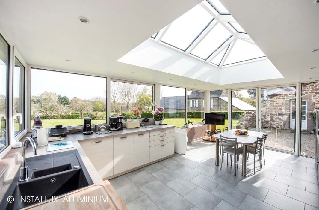 Cuisine moderne avec un grand puits de lumière et de larges fenêtres donnant sur une cour arrière.