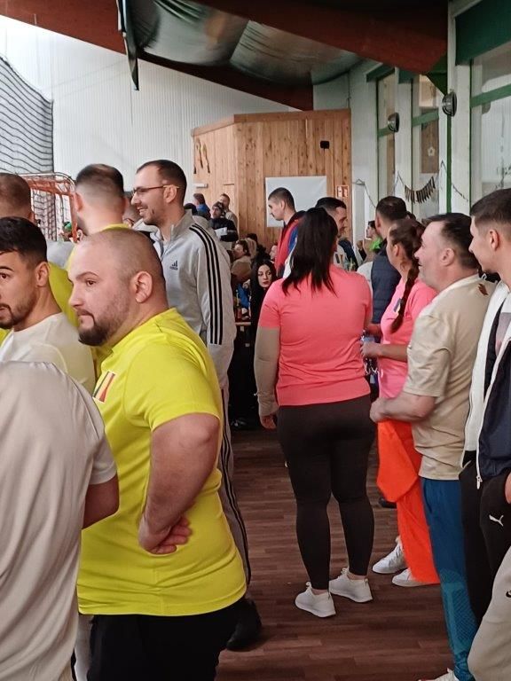 Eine Menschenmenge im Gebäude, einige in Sportkleidung, wartet in einer Schlange.