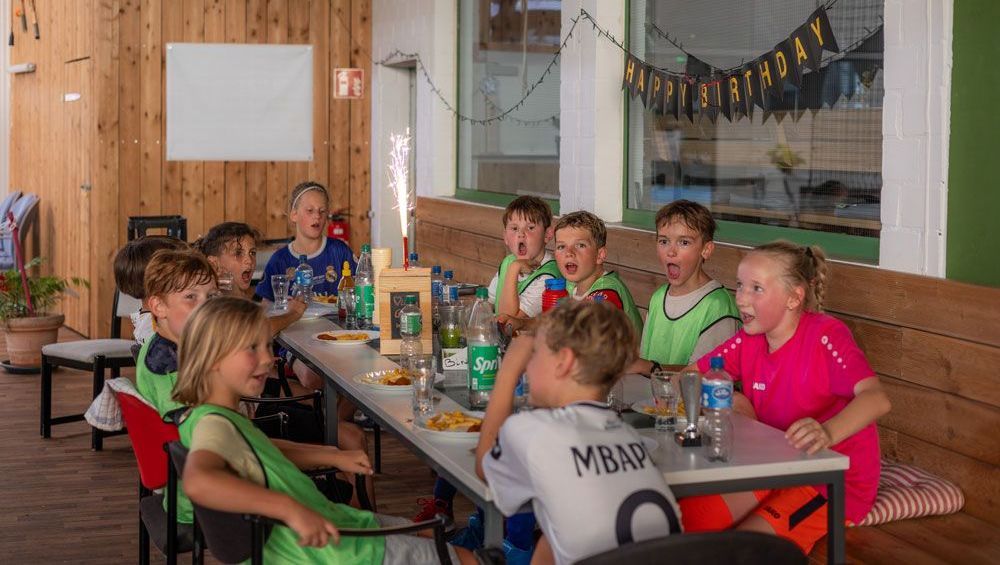 Ein Tisch mit Tellern, Gläsern und einer Wunderkerze darauf.