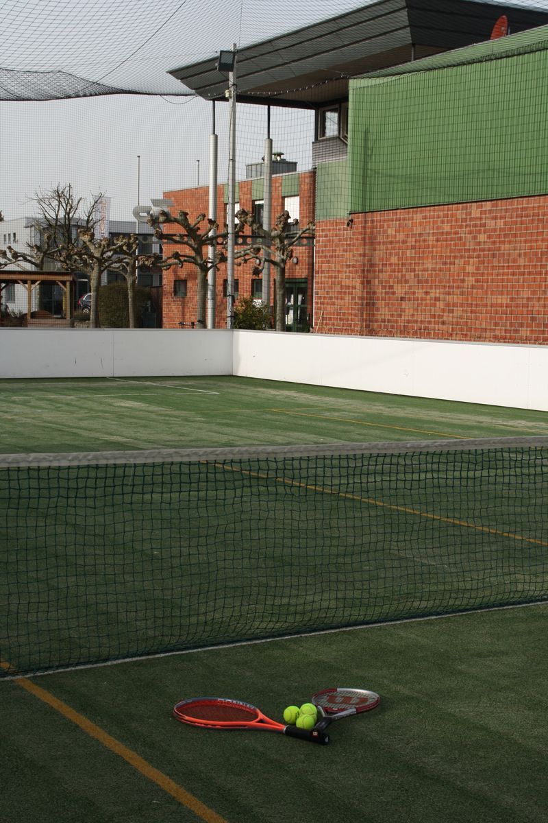 Ein Tennisplatz mit einem Schläger und Bällen darauf