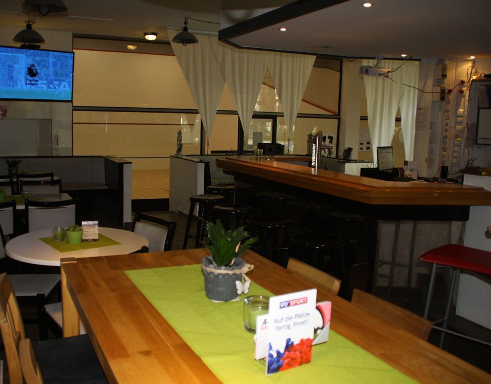 Ein Restaurant mit Tischen und Stühlen und einem Fernseher an der Wand