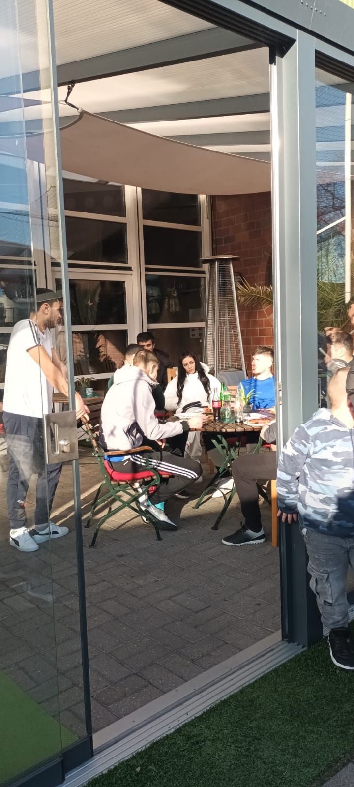 Eine Gruppe von Leuten sitzt an Tischen in einem Restaurant.