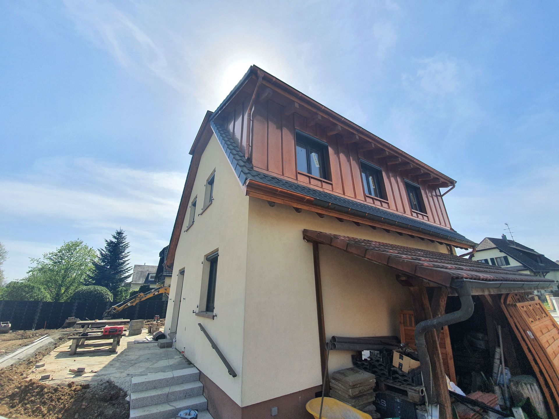 Es entsteht ein weißes Haus mit Holzdach.