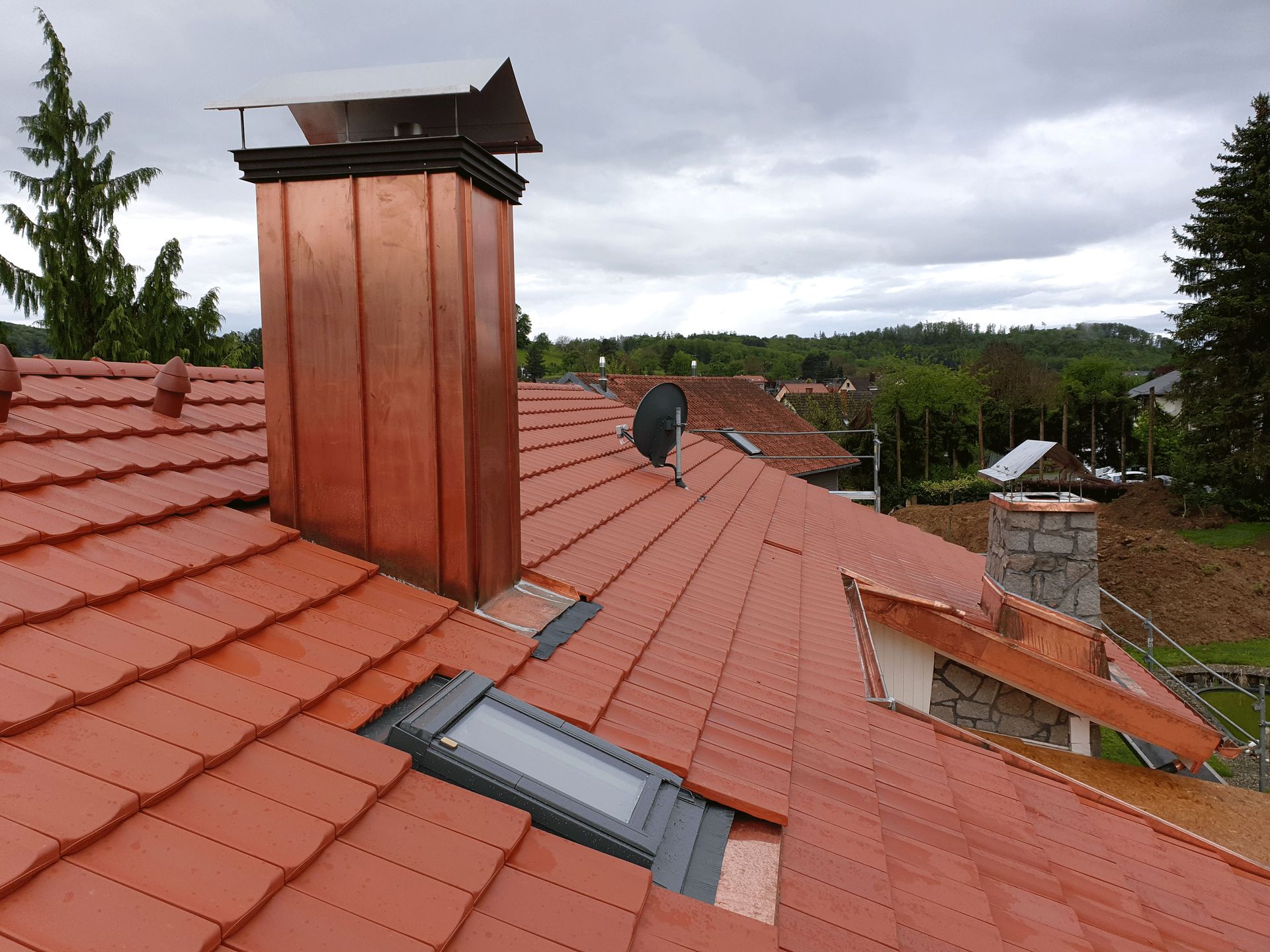 Auf dem Dach eines Hauses befindet sich ein Kupferschornstein