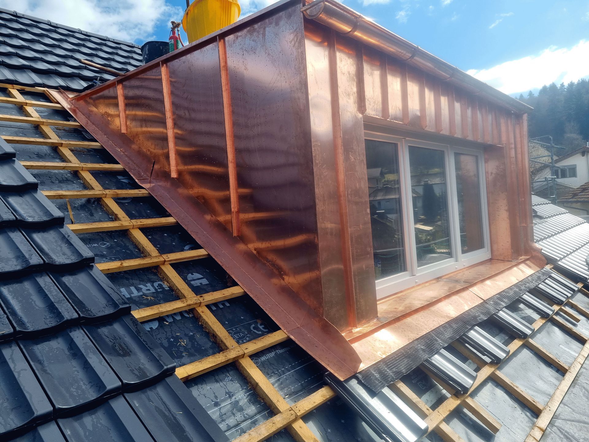 Es wird ein Kupferdach mit einem Fenster darauf gebaut.