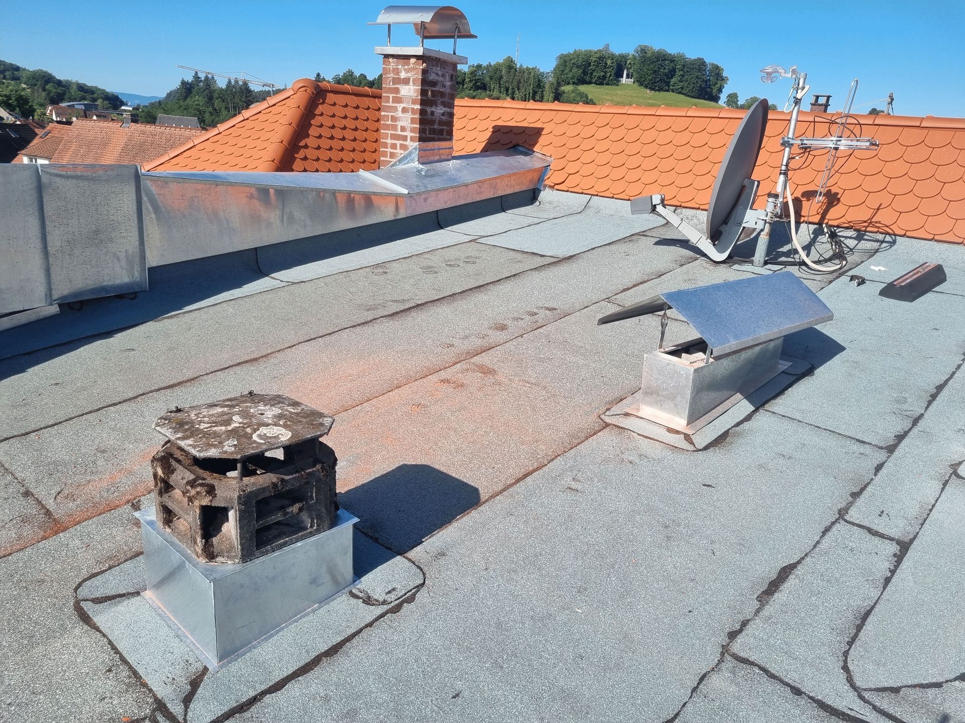ein Dach mit einem Schornstein und einer Satellitenschüssel darauf