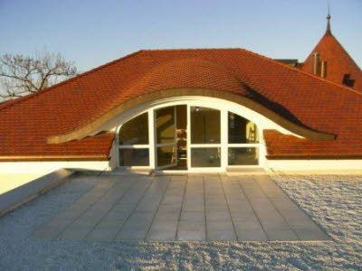 Ein Gebäude mit einem roten Dach und Bogenfenstern