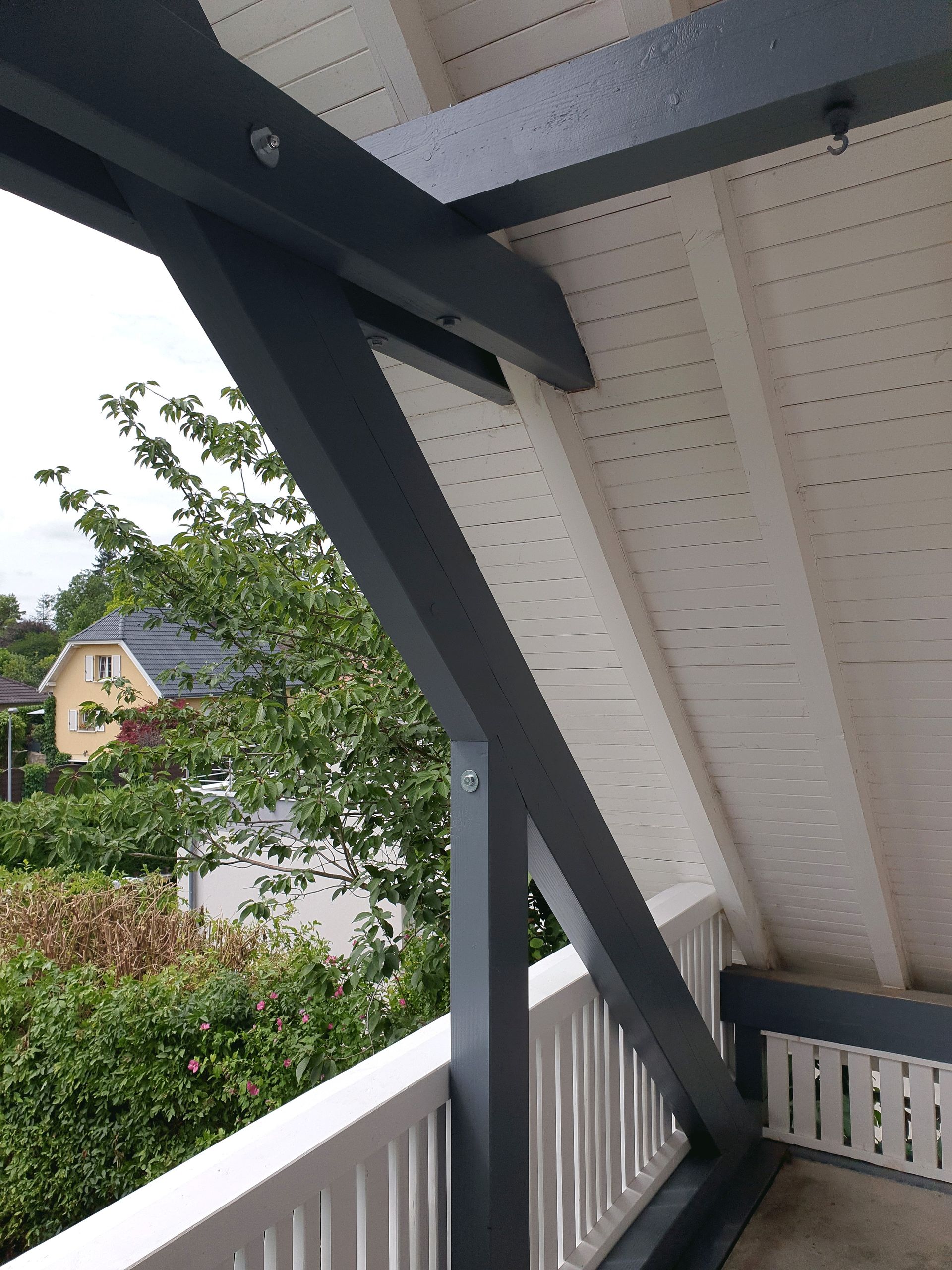 Ein Balkon mit Blick auf ein Haus und Bäume