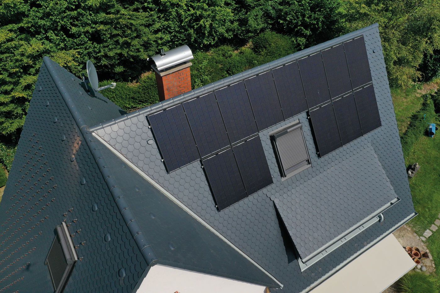 Eine Luftaufnahme eines Hauses mit Solarmodulen auf dem Dach.